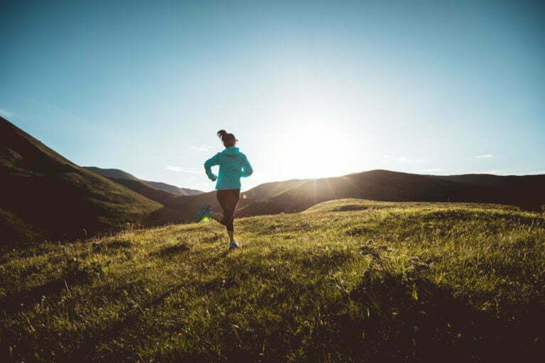 Young woman runner running at mountain top